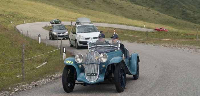 Il vincitore guida un serpentone sui passi delle Dolomiti.